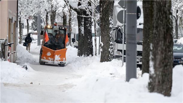 Winterwetter führt zu Flughafen-Stillstand in München Ein Räumfahrzeug fährt über einen verschneiten Weg in München.
