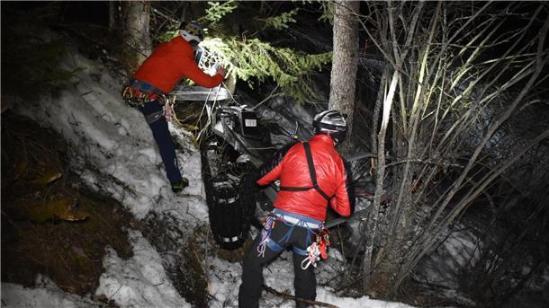 Ein Rettungsteam arbeitet an der Unglückstelle nach einem nächtlichen Unfall mit einem Motorschlitten.