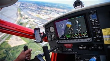 Ein Pilot steuert einen Motorsegler. 
