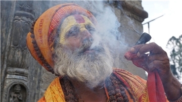 Ein Sadhu (ein heiliger Mann) raucht Marihuana auf dem Gelände eines Tempels in Kathmandu.