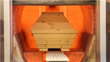 Ein Sarg wird in einem Krematorium verbrannt.