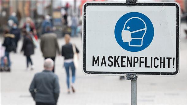 Ein Schild, auf dem "Maskenpflicht" steht, steht in der Fußgängerzone.