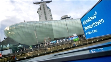 Ein Schild weist den Weg zum Klimahaus Bremerhaven. 