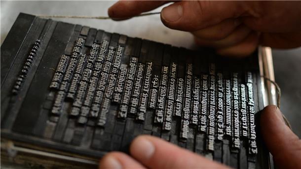 150 Jahre Flächentarifvertrag - Totgesagte leben länger Ein Schriftsetzer des Museums für Druckkunst Leipzig bindet in Leipzig Bleilettern mit einer Kolumnenschnur ein.