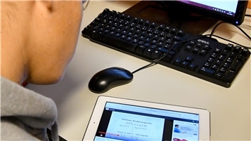 Ein Schüler löst eine Aufgabe mit iPad und Computer. Auch in den Schulen sind digitale Lernmittel auf dem Vormarsch.