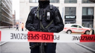 Ein schwer bewaffneter Polizist hinter einem Absperrband in der Züricher Innenstadt (Symbolbild).