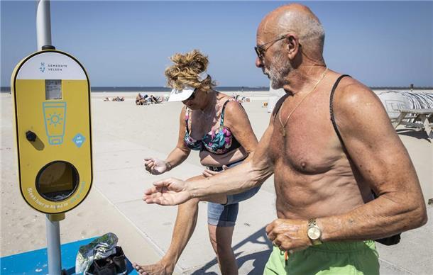 Sonnencreme statt Desinfektionsmittel: Die Niederländer machen’s vor Ein Spender mit kostenlosem Sonnenschutz steht an einem Strand, um Besucher vor Sonnenbrand zu schützen. In den Niederlanden können Menschen in diesem Sommer an Hunderten Orten kostenlos Sonnencreme erhalten.