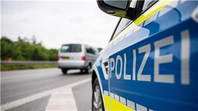 Ein Streifenwagen der Polizei steht auf einer Straße.