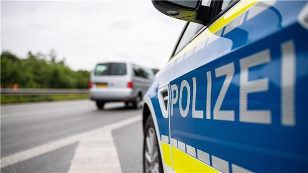Ein Streifenwagen der Polizei steht auf einer Straße.