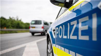 Ein Streifenwagen der Polizei steht auf einer Straße.