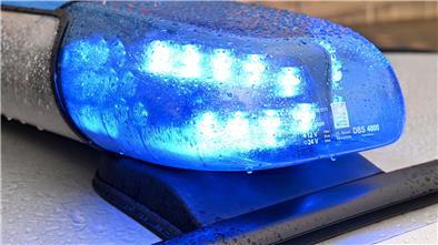 Ein Streifenwagen der Polizei steht mit eingeschaltetem Blaulicht an einem Einsatzort.