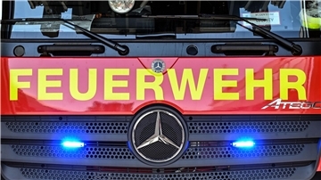 An einem Feuerwehrfahrzeug leuchten unter dem Schriftzug „Feuerwehr“ zwei Blaulichter.  Ein Strohdachhaus in Ringstedt konnte dank des schnellen Handelns der Feuerwehr vor einem größeren Brand bewahrt werden.