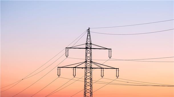 Stromsteuer-Senkung für Industrie teuer als geplant Ein Strommast bei Sonnenaufgang.
