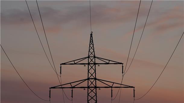 Ein Strommast in der Abenddämmerung.