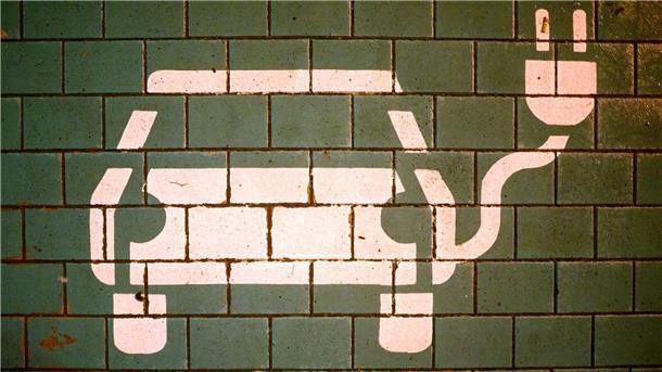 Nachfrage nach Elektroautos steigt weiter Ein Symbol markiert einen Parkplatz mit einer öffentlichen Ladesäule für Elektroautos.