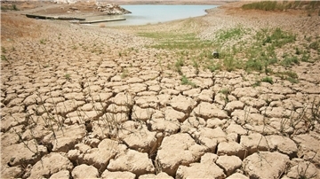 Ein Symptom des schlechten Zustands der Erde: von der Trockenheit zerklüftete und aufgerissene Erde an den Ufern des Viñuela-Stausees in Spanien.