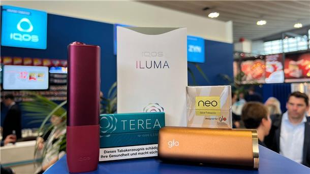 Weg von der Kippe? Zigarettenkonzerne bewerben Alternativen Ein Tabakerhitzer der Marke Iqos vom Hersteller Philip Morris und ein dazugehöriges Päckchen Tabaksticks der Marke Terea sowie das Konkurrenzprodukt Glo (mit Neo-Tabaksticks) des Herstellers BAT liegen bei der Fachmesse Intertabac in einer Messehalle.