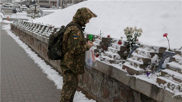 Ein ukrainischer Soldat gedenkt in Kiew den Menschen, die bei Zusammenstößen mit Sicherheitskräften auf dem Maidan-Platz im Jahr 2014 ums Leben kamen.