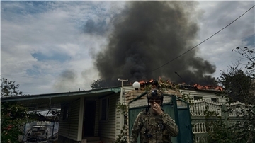 Ein ukrainischer Soldat geht an einem Haus vorbei, das nach einem Beschuss in der Nähe der Frontlinie abgebrannt ist. Russland führt seit Februar 2022 Krieg gegen die Ukraine.