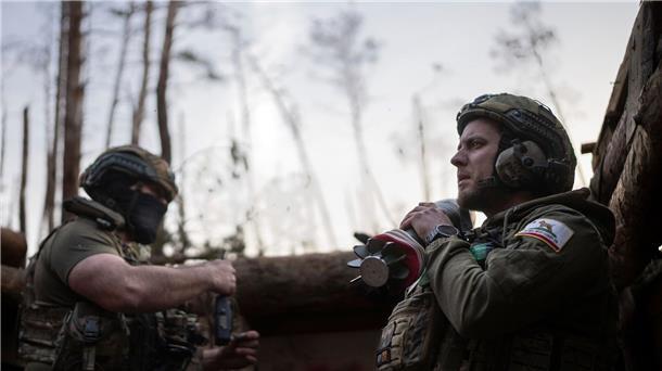 Ein ukrainischer Soldat trägt eine Mörsergranate, während er auf einen Feuerbefehl wartet.