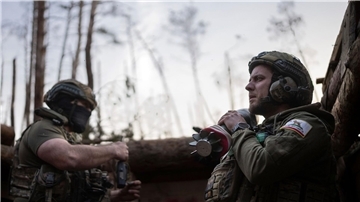 Ein ukrainischer Soldat trägt eine Mörsergranate, während er auf einen Feuerbefehl wartet.