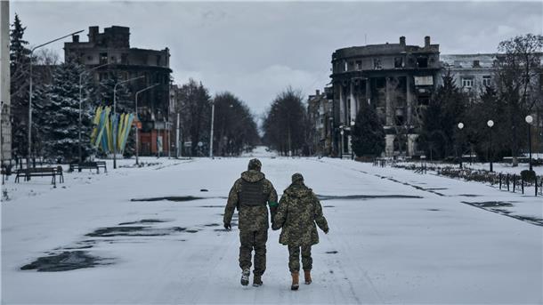 Ein ukrainischer Soldat und eine Soldatin gehen händchenhaltend durch Bachmut. In der schwer umkämpften Stadt im Osten des Landes geraten die ukrainischen Streitkräfte immer stärker unter Druck.