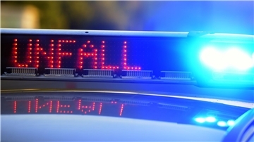 Bild von einem Polizeiwagen, auf dessen Dach ein Leuchtband mit der Aufschrift "Unfall" zu sehen ist.