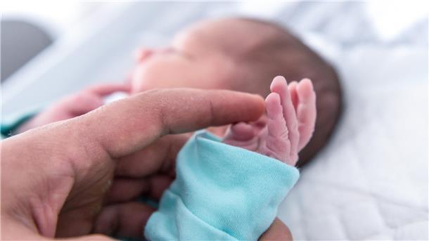Ein Vater hält die Hand eines wenige Tage alten Jungen. In der Helios-Klinik Cuxhaven gibt es derzeit nicht genügend Ärzte, um die Geburtshilfe und den Bereich Kinder- und Jugendmedizin durchgängig zu besetzen.