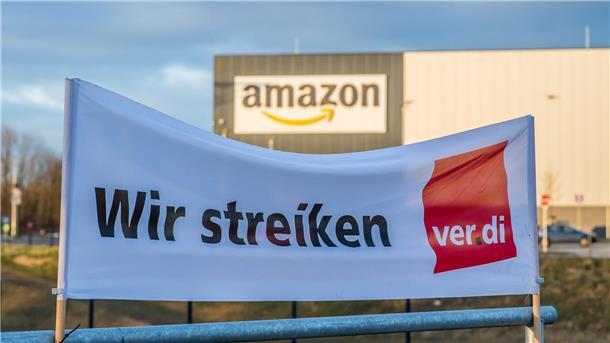 Ein Verdi Banner mit der Aufschrift: „Wir streiken“ steht vor dem Amazon-Logistik-Zentrum.