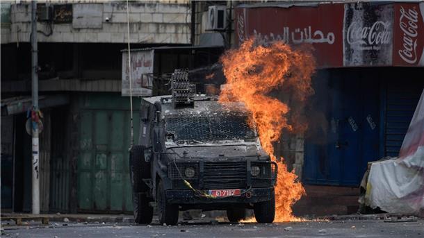 Zwei bewaffnete Palästinenser bei Razzia in Nablus getötet Ein von einem palästinensischen Demonstranten geworfener Molotowcocktail explodiert auf einem israelischen gepanzerten Fahrzeug in Nablus.