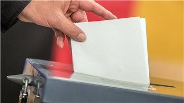 Ein Wähler wirft seinen Stimmzettel zur Bundestagswahl in die Wahlurne.