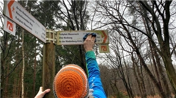 Ein Wegepate reinigt einen Wegweiser (c) Touristikverband