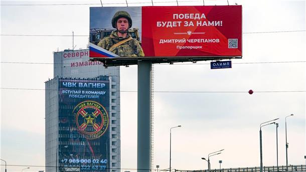 Privatarmeen bringen Putins Gewaltmonopol in Gefahr Ein Werbeschild, auf dem für das Militärunternehmen Wagner (hinten) geworben wird und auf dem zu lesen ist „Schließen Sie sich dem Team der Sieger an“.