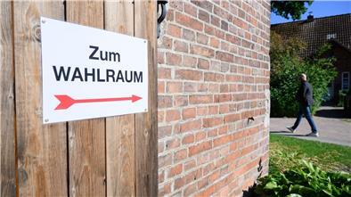 Ein Zettel „Zum Wahlraum“ zeigt den Weg zu einem Wahllokal zur Europawahl auf einem Hof in der Region Hannover.