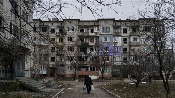UN-Bericht: Zivilisten in russischem Gewahrsam gefoltert Ein Zivilist geht an schwer beschädigten Wohngebäuden in Soledar vorbei.