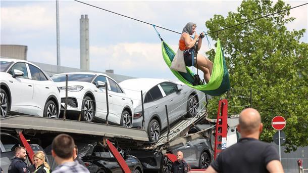 Effizienzprogramm soll Volkswagen Gewinne bringen Eine Aktivistin hängt an einem Seil über der Liefereinfahrt ins VW-Stammwerk in Wolfsburg.