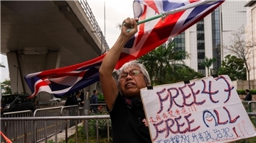 Eine als „Oma Wong“ bekannte Demokratieaktivistin protestiert in Hongkong. Die Polizei hat Haftbefehle gegen fünf weitere im Ausland lebende Aktivisten erlassen.