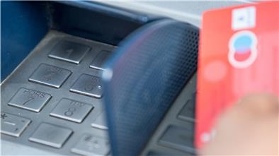 Bargeld in Krisenzeiten: Sauber und sicher? Eine Bankkundin hebt mit ihrer Girokarte Bargeld von einem Geldautomaten ab.