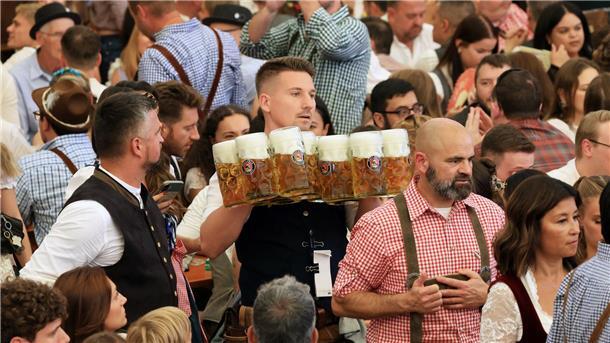 190. Oktoberfest: „Gegen die Krisen der Welt“ Eine Bedienung schleppt Maßkrüge durch ein Wiesn-Festzelt.