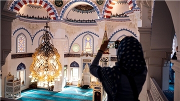 Eine Besucherin fotografiert die Sehetlik-Moschee am Columbiadamm in Berlin.