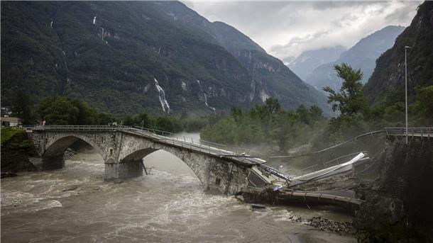 Eine Brücke im Maggiatal wird durch einen reißenden Fluss zerstört.