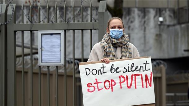 Eine Demonstrantin hält ein Plakat mit der Aufschrift «Don't be silent stop PUTIN» in den Händen. Ukrainer demonstrieren vor dem Generalkonsulat in Bonn gegen den Angriff Russlands auf ihr Land.