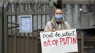 Eine Demonstrantin hält ein Plakat mit der Aufschrift «Don't be silent stop PUTIN» in den Händen. Ukrainer demonstrieren vor dem Generalkonsulat in Bonn gegen den Angriff Russlands auf ihr Land.