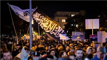 Eine Fahne mit arabischer Schrift weht bei der Kundgebung „Gaza unter Beschuss - gemeinsam gegen das Unrecht“.
