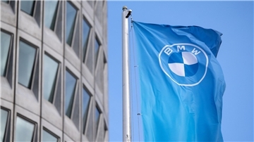 Eine Fahne mit dem BMW-Logo vor der Firmenzentrale in München. Der Automobilhersteller legt neue Quartalszahlen vor.