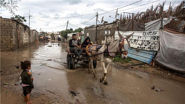 Eine Familie fährt mit einer Kutsche über einen überschwemmten Weg. Schwere Regenfälle und Überschwemmungen beeinträchtigen das tägliche Leben der Palästinenser in der Stadt Khan Yunis im südlichen Gazastreifen.