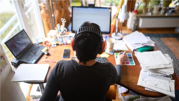 Firmen sehen keinen Produktivitätsverlust im Homeoffice Eine Frau arbeitet mit Hörschutz im Homeoffice.