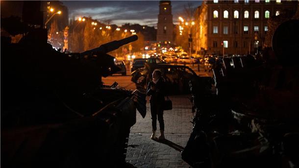 Krieg gegen die Ukraine: So ist die Lage Eine Frau betrachtet zerstörte russische Panzer in Kiew.
