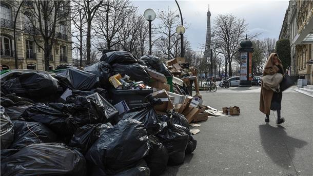 Frankreich: Rentenrefom beschlossen, Regierung abgestraft Eine Frau geht in Paris an nicht abgeholten Müllsäcken vorbei. Seit Wochen wird das öffentliche Leben in Frankreich durch die Proteste gegen die Rentenreform eingeschränkt - auch durch Streiks bei der Müllabfuhr.