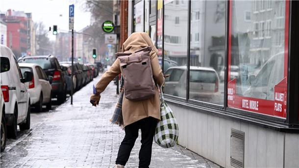 Glatteis: Deutschland rutscht in die Weihnachtswoche Eine Frau schlittert über den vereisten Gehweg in Kassel.